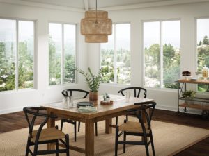 A dining nook in a home that is surrounded by sliding windows.